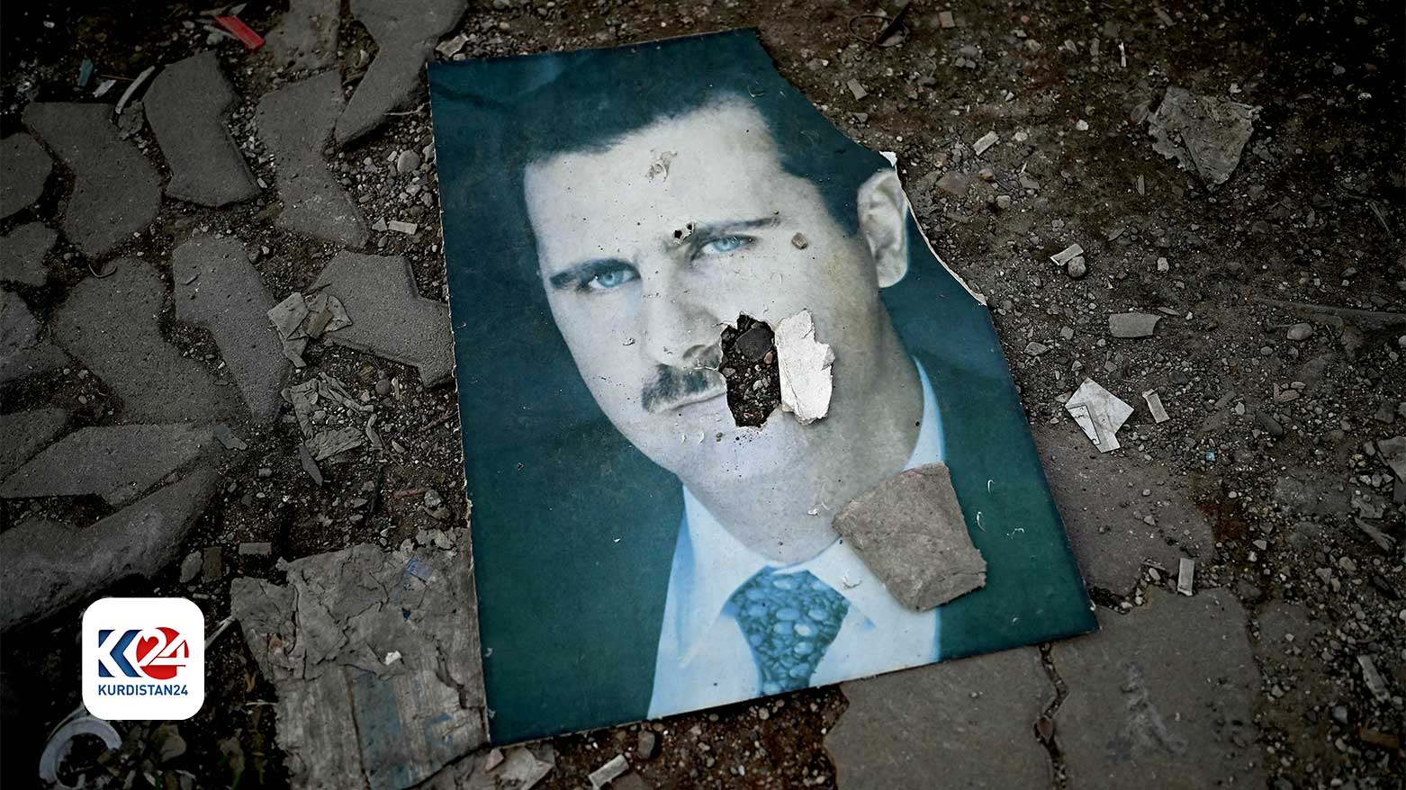 A damaged portrait of Syria's ousted president Bashar al-Assad lies on the ground in the western Syrian port city of Latakia on Dec. 15, 2024. (Photo: AFP)