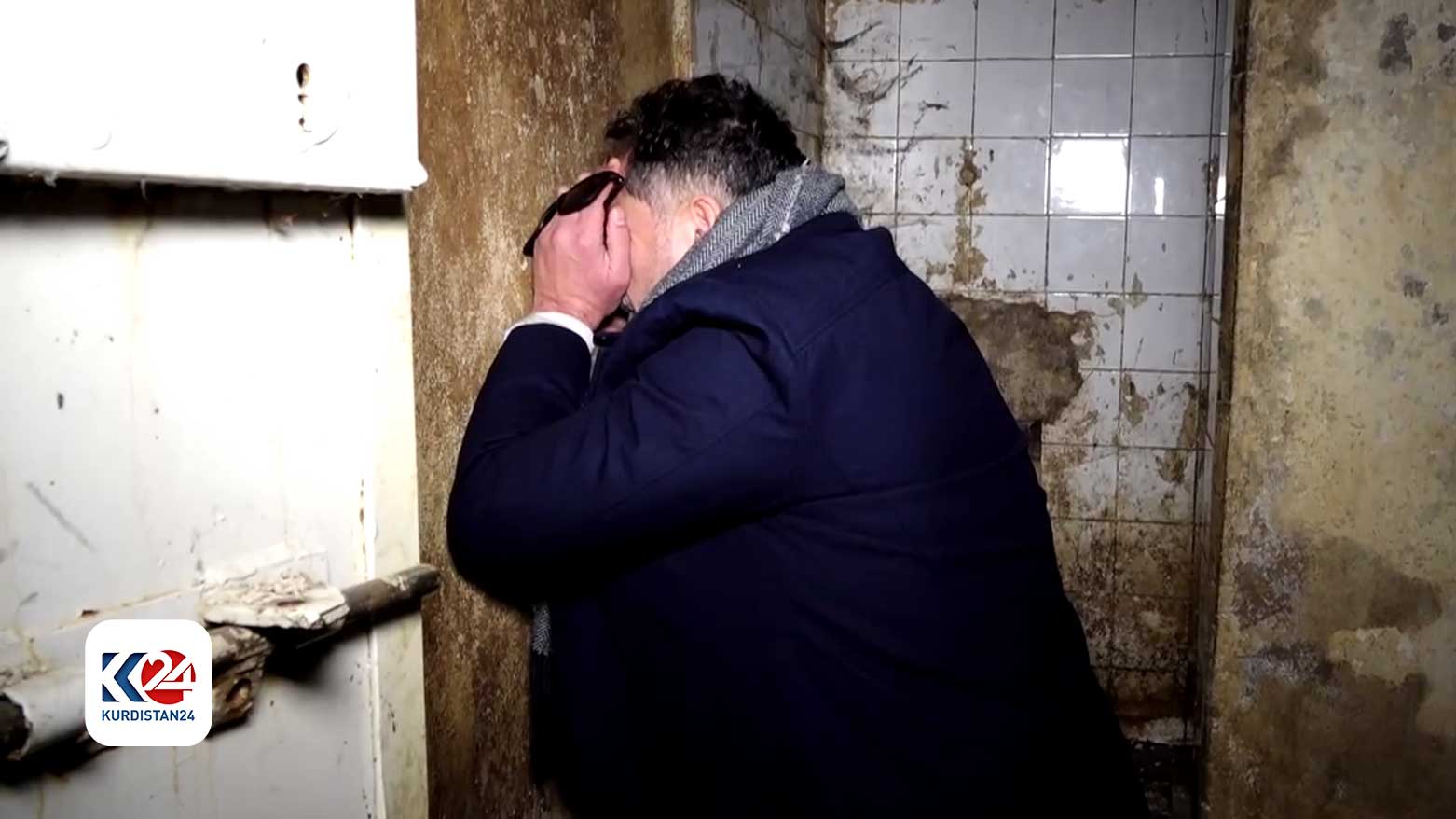 Shabal posing as the way he was forced into the small cell in Saydnaya. (Photo: Kurdistan24)
