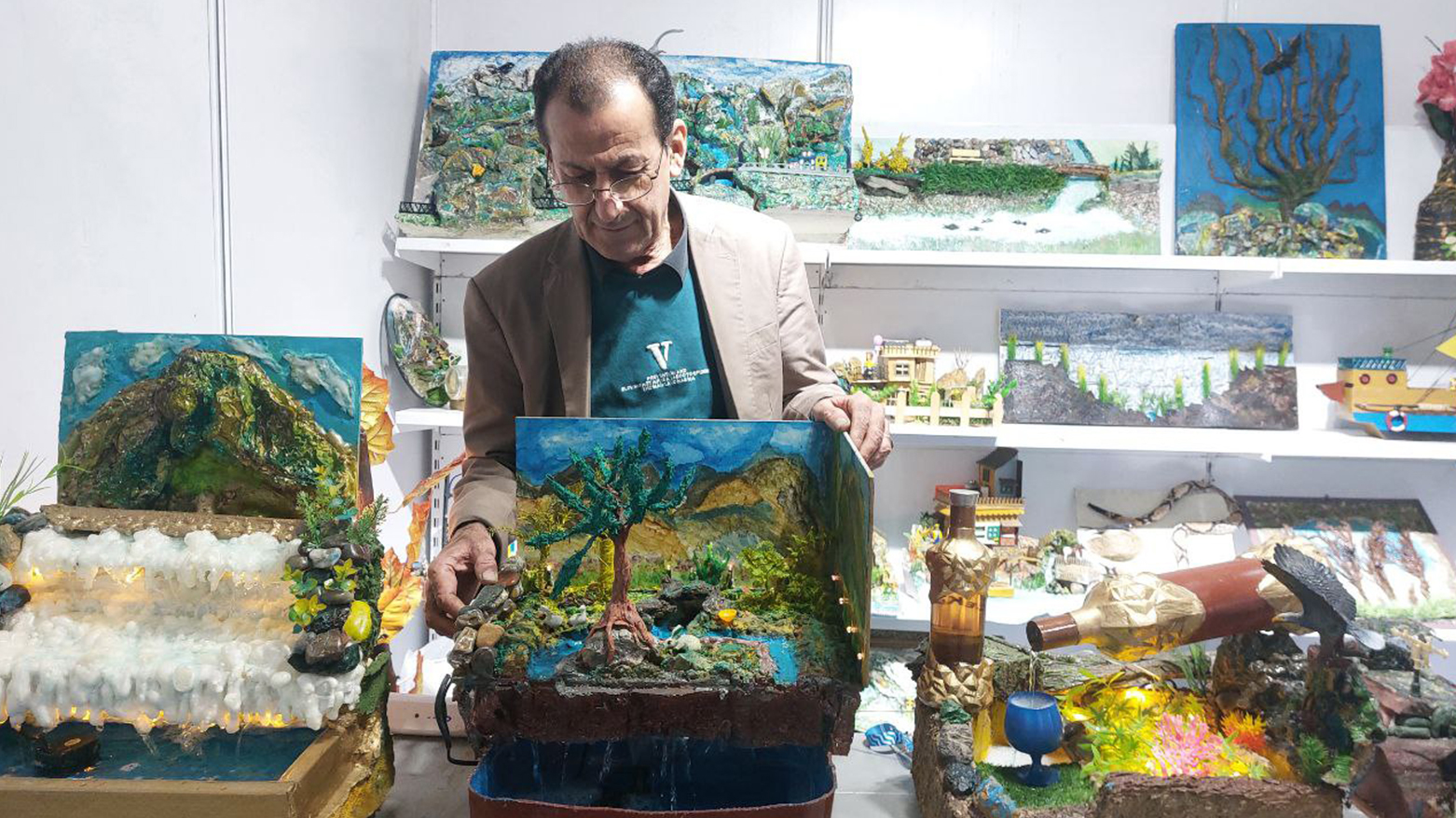 فنانٌ من السليمانية يصمم لوحاته من التراب والنفايات