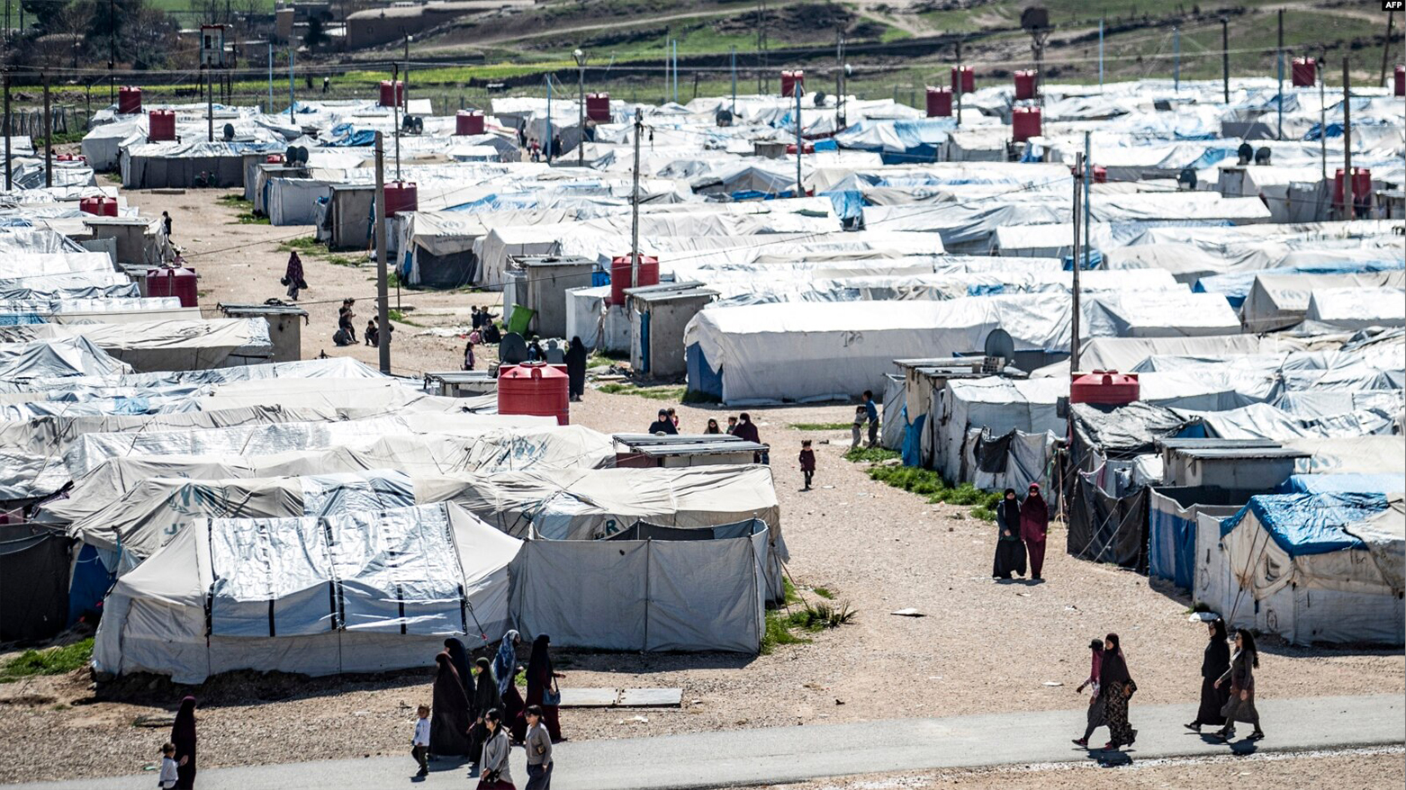 Women and children walk at Roj camp, where relatives of people suspected of belonging to ISIL are held, in the countryside near al-Malikiyah in Syria's northeastern Hasakah province, March 28, 2021. (AFP)