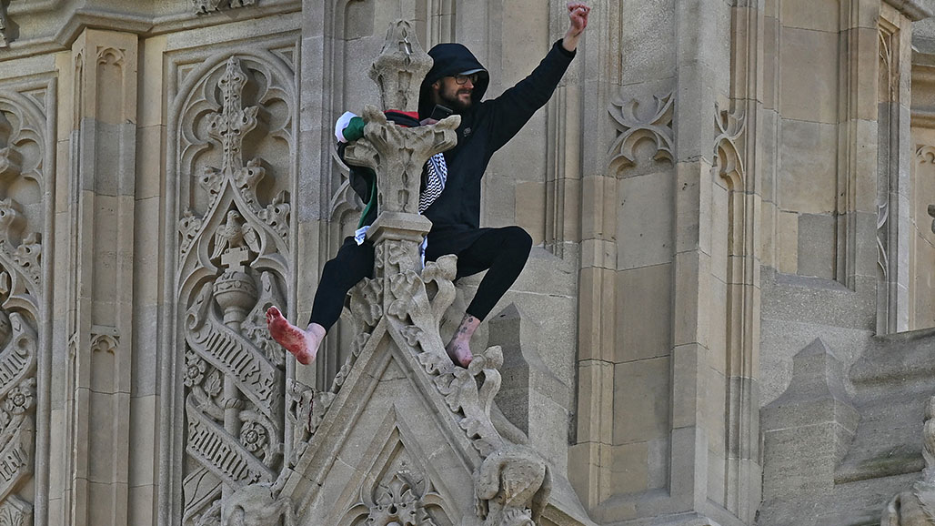 رجل يتسلق برج بيغ بن في لندن رافعا العلم الفلسطيني