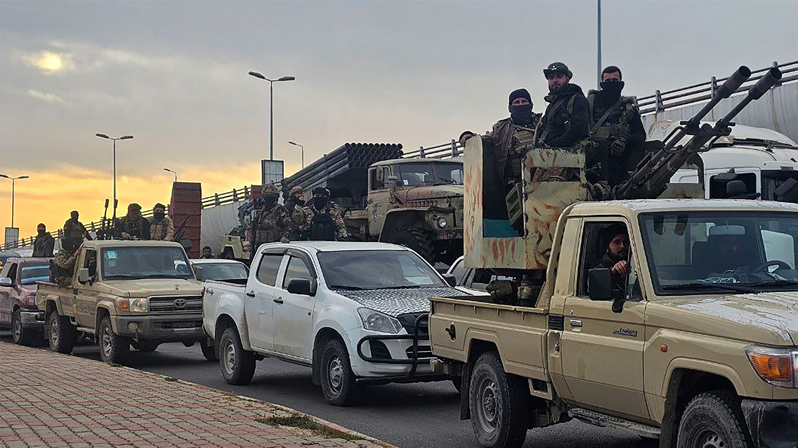 Members of the Syrian security forces entering the Mediterranean city of Tartous to reinforce government troops in clashes with militants loyal to deposed ruler Bashar al-Assad, on Mar. 7, 2025. (Photo: AFP, Designed by Kurdistan24)