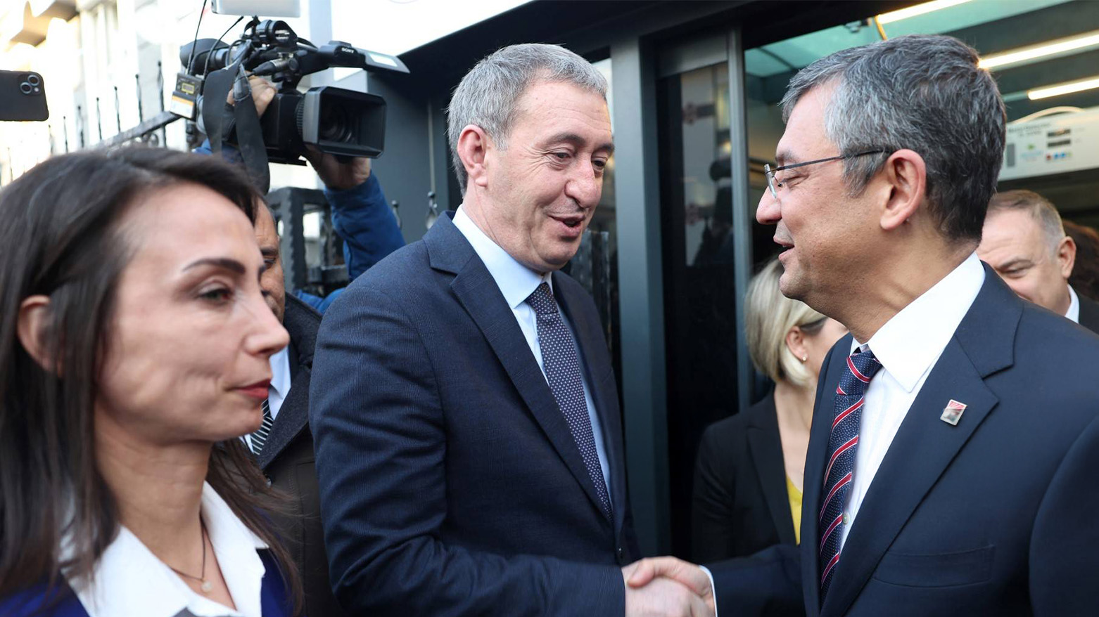 CHP leader Özgür Özel (R) shakes hands with DEM co-chair Tuncer Bakırhan (C) as Tülay Hatimoğulları (L) looks on at DEM headquarters, Ankara, Dec. 13, 2023. (Photo: AFP)