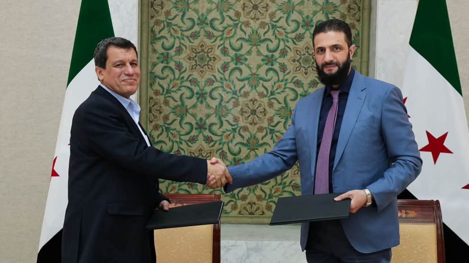 Syria's interim president Ahmed al-Sharaa (R) shaking the hand of SDF commander-in-chief Mazloum Abdi after the signing of an agreement, to integrate the SDF into the state institutions, in the Syrian capital Damascus on March 10, 2025. (Photo: SANA)