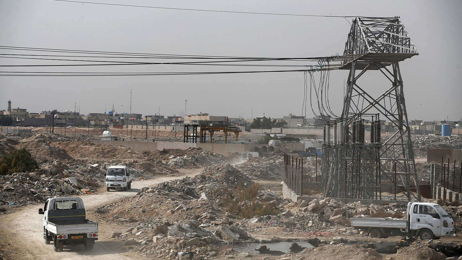 This photograph taken on January 21, 2024 shows vehicles driving under electricity wires in al-Fadiliya, east of Baghdad. (Photo: AFP)