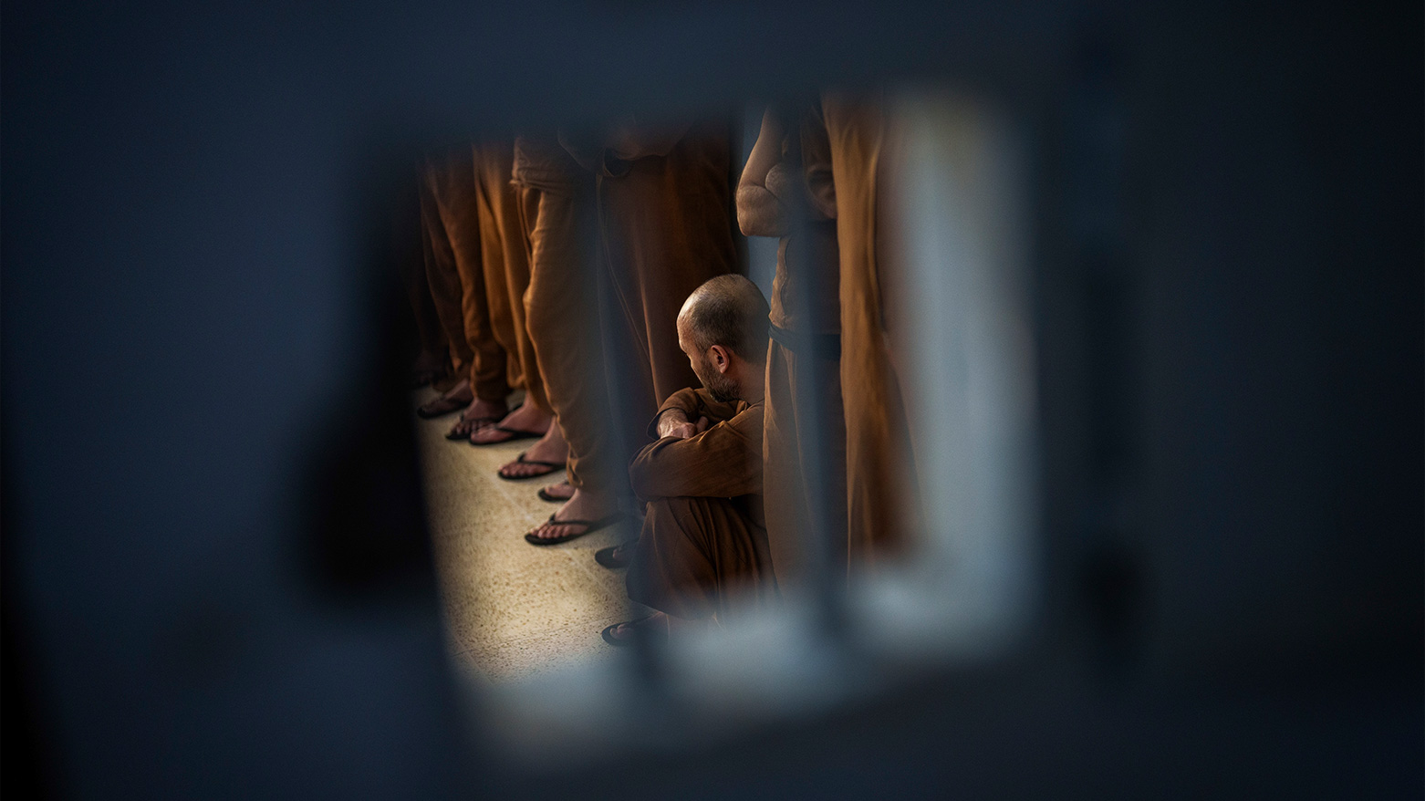 A man accused of being an Islamic State (ISIS) fighter as others stand inside a cell at the Syrian Democratic Forces-run Gweiran Prison. (Photo: AP)