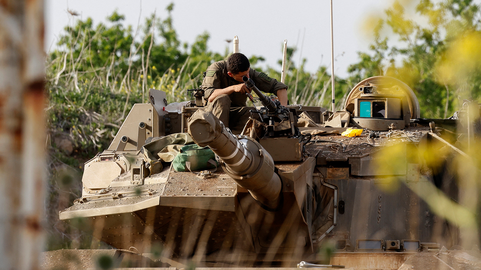 An Israeli soldier checks a Merkava battle tank deployed at a position in the Israel-annexed Golan Heights along the border with southern Syria on Mar. 25, 2025.(Photo: AFP)