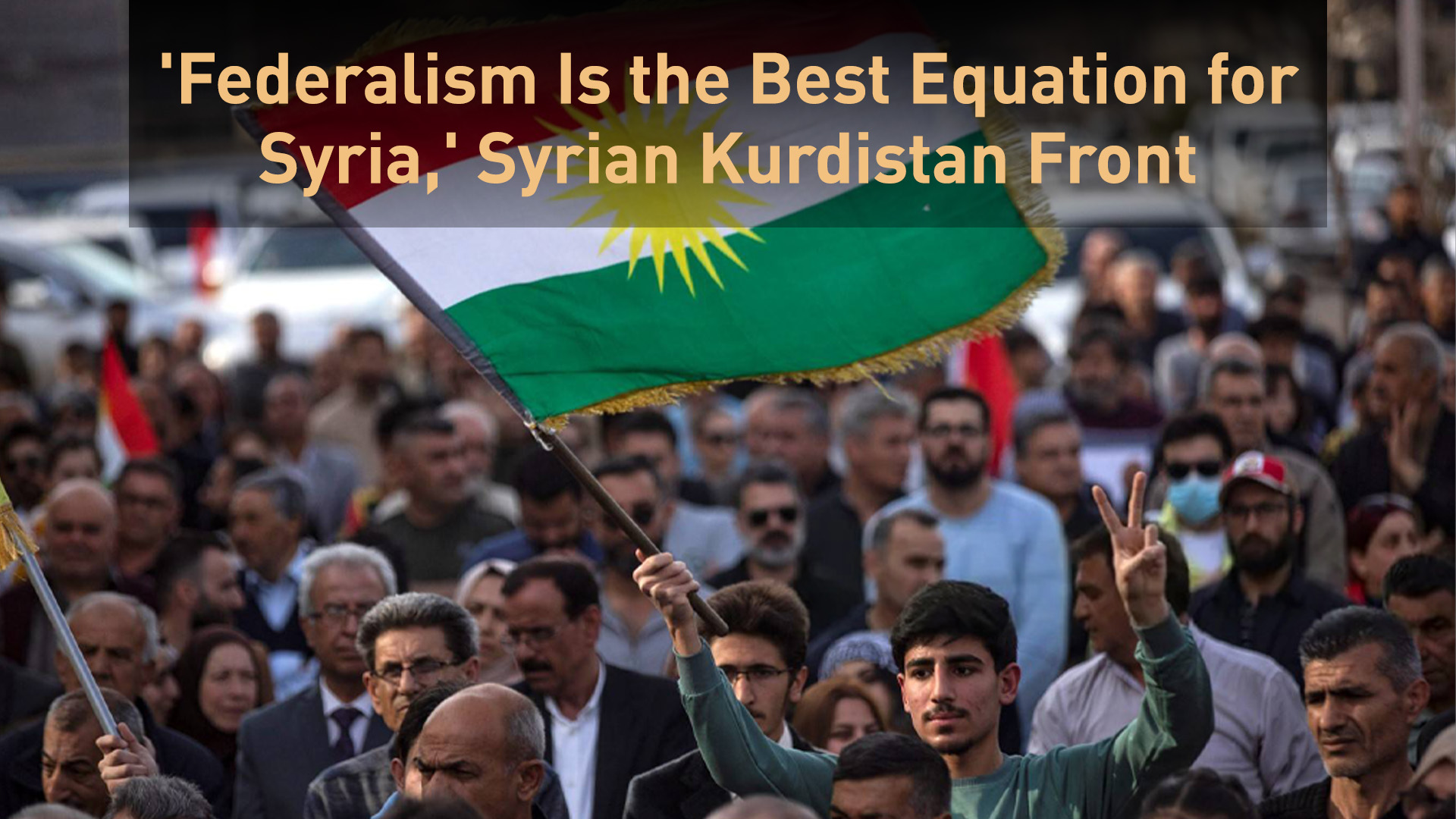 A man flashes the V for victory sign and waves the Kurdish flag as Kurds demonstrate in the northeastern city of Qamishlo on March 14, 2025. (Photo: AFP)