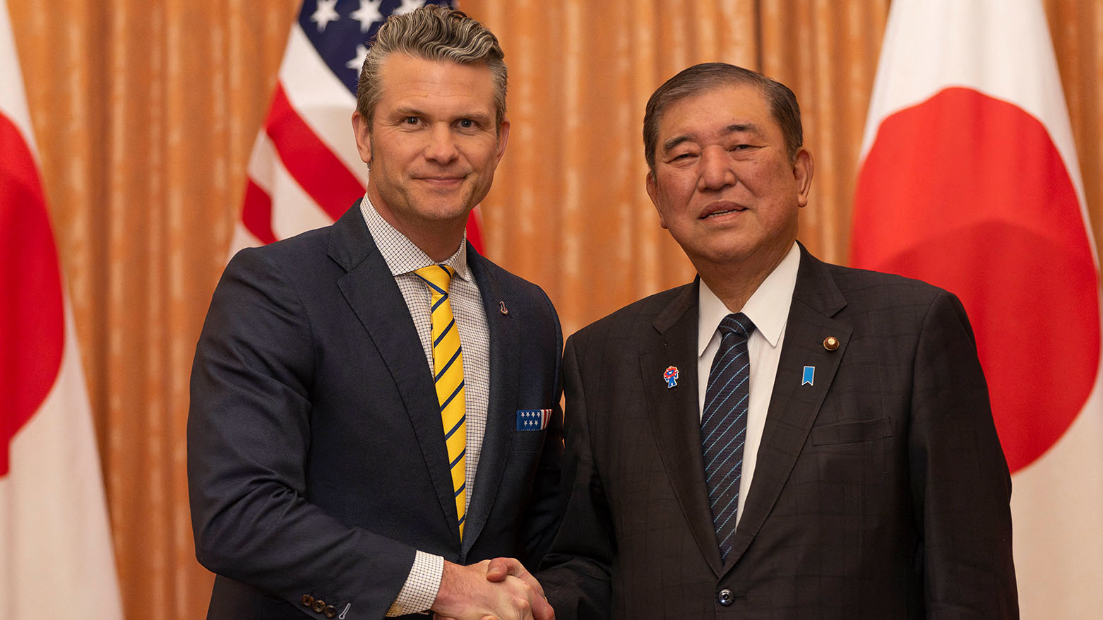 U.S. Secretary of Defense Pete Hegseth (L) shakes hands with Japanese PM Shigeru Ishiba at the prime minister's office in Tokyo Sunday, March 30, 2025. (Photo: AP)
