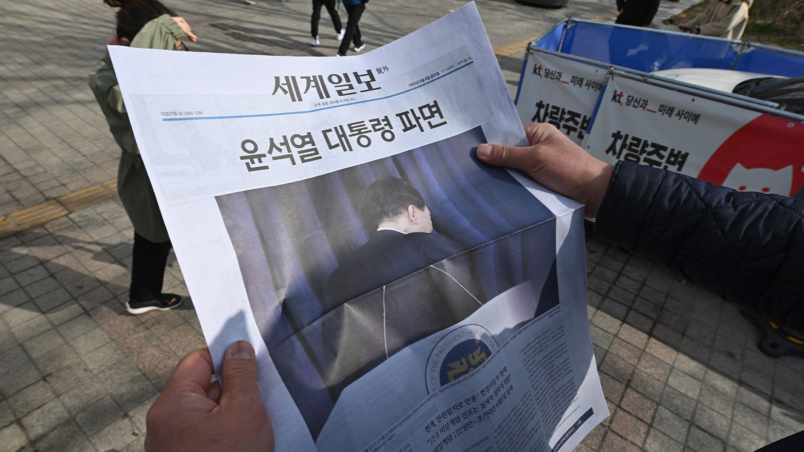 A man reads an extra edition in Seoul on April 4, 2025, after the court upheld President Yoon's impeachment. (Photo: AFP)