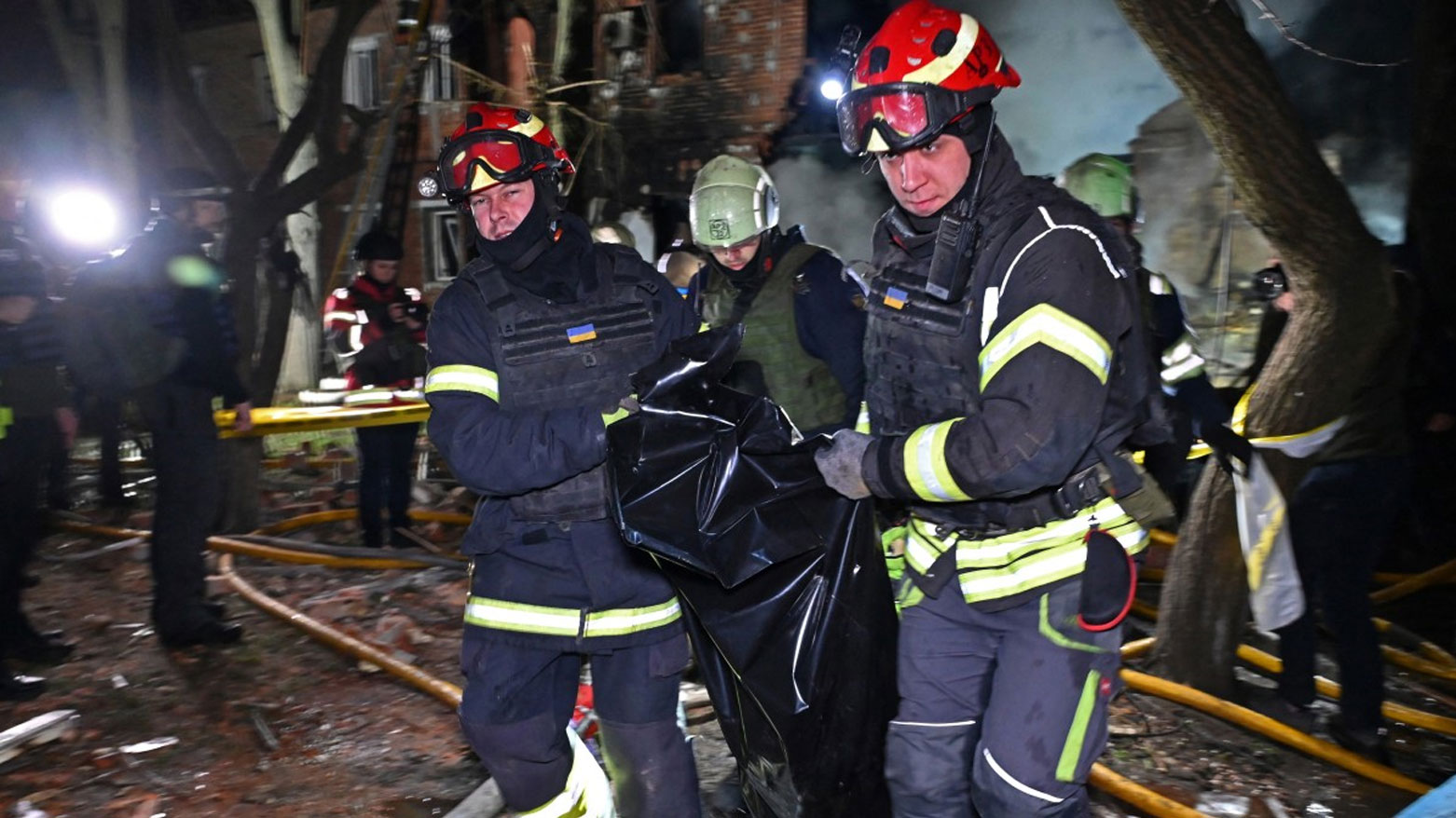 أفراد الطوارئ ينتشلون جثة أحد الضحايا من موقع هجوم بطائرة مسيرة في خاركيف (فرانس برس)