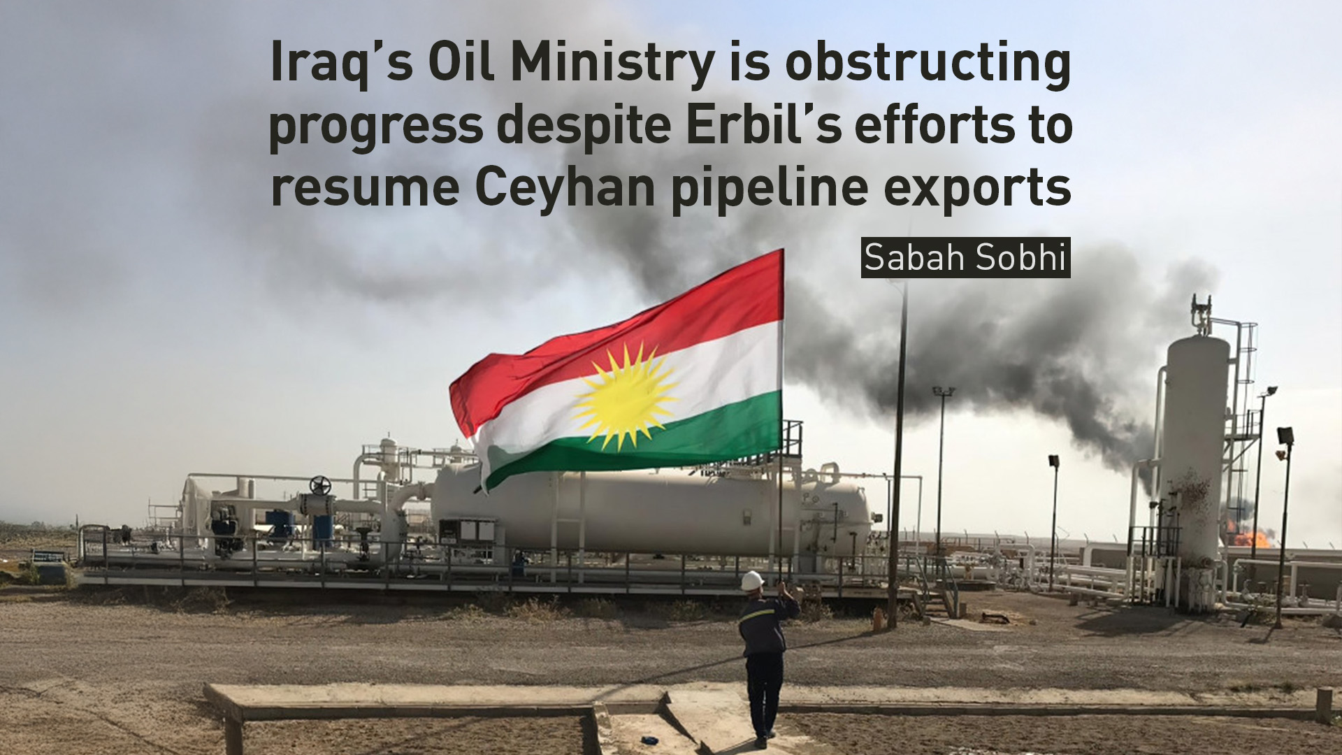 An oil refinery worker holds the Kurdistan flag. (Graphic: Design by Kurdistan24)
