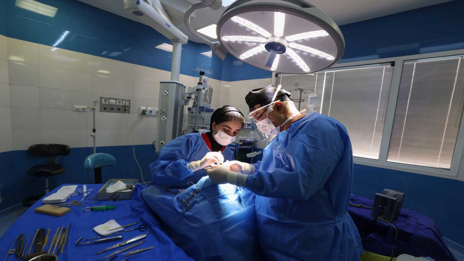 Iranian surgeon Hamidreza Hosnani (R) and an assistant, perform a nose operation at his private clinic in Tehran, March 4, 2025. (Photo: AFP)
