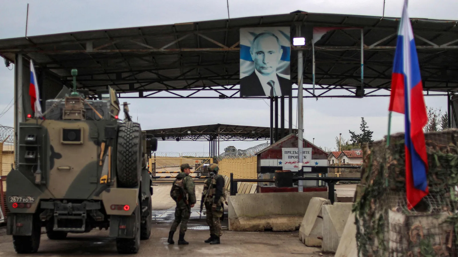 A portrait of Russia's President Vladimir Putin hangs above as Russian military trucks enter the Russian-leased Syrian military base of Hmeimim in Latakia province in western Syria on December 29, 2024. (Photo: AFP)