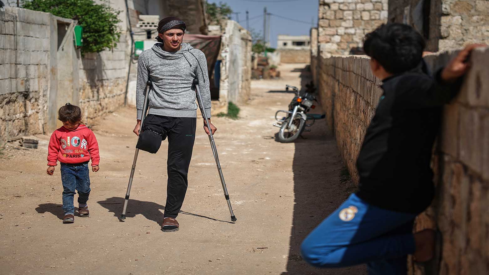 Suleiman Khalil, 21, who lost his leg in a landmine explosion while harvesting olives with his friends in a field, walks outside his home in Idlib, Syria, April 9, 2025. (Photo: AP)