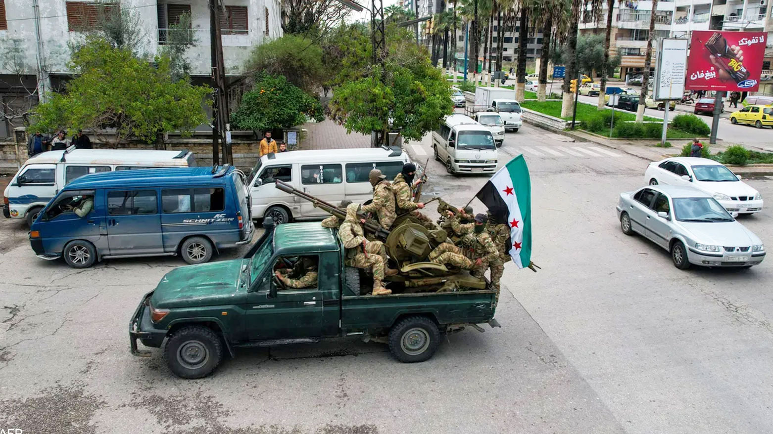 Syrian soldiers inside a military vehicle raise the Syrian flag on a street in the capital, Damascus (AFP).