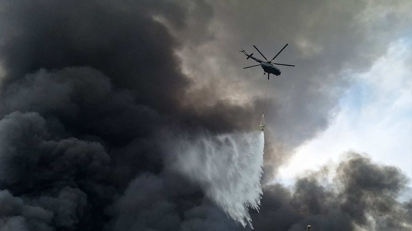 A helicopter sprays water at the scene of an explosion that took place a day earlier at the Shahid Rajaee port dock, southwest of Bandar Abbas in the Iranian province of Hormozgan, on Apr. 27, 2025. (Photo: AFP)