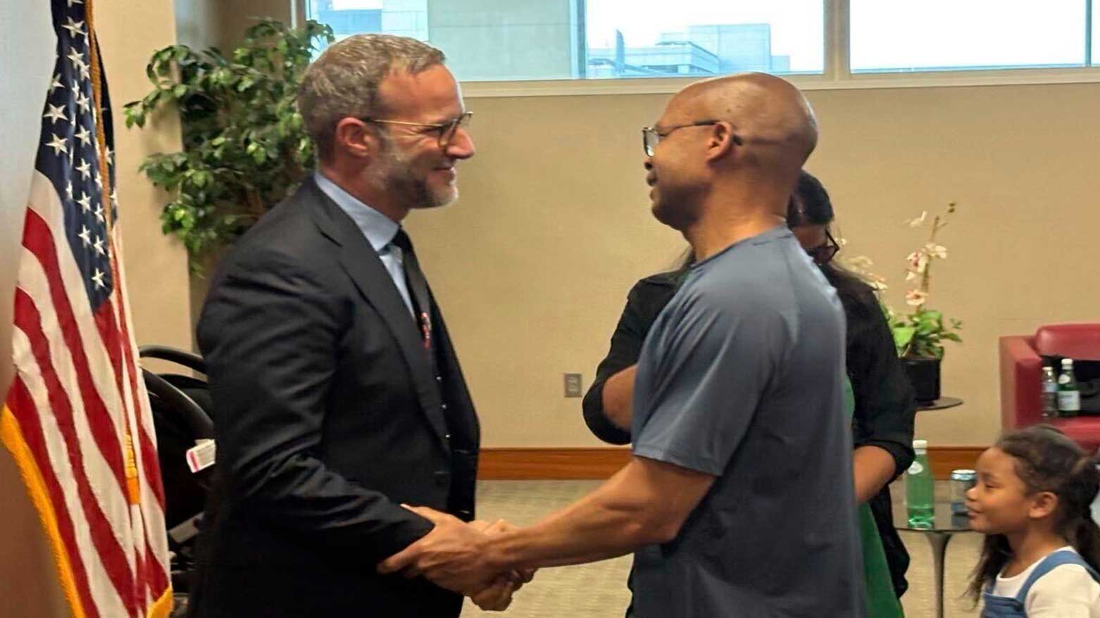 Adam Boehler, the Trump administration's top envoy for hostage affairs, (L), greets military contractor Tony Holden, who was recently released from Kuwait, at Washington Dulles International Airport, April 30, 2025. (Photo: AP)