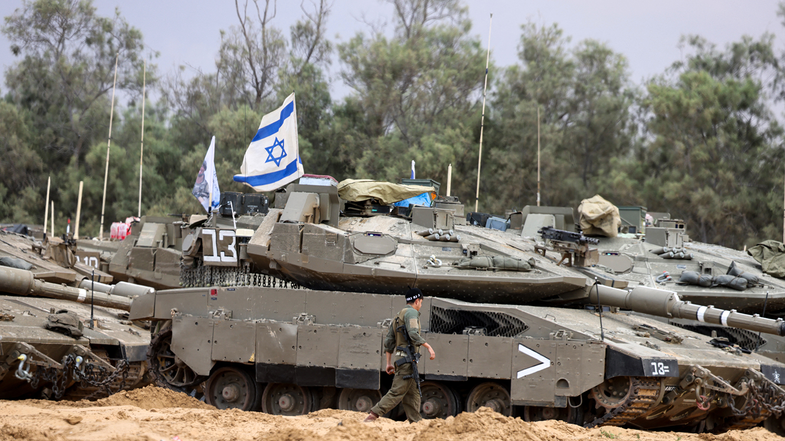 An Israeli soldier walks near tanks deployed at a position near Israel's border with the Gaza Srip on May 4, 2025. (Photo: AFP)
