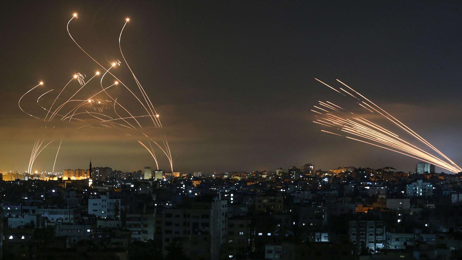 The Israeli Iron Dome missile defence system (L) intercepts rockets (R) fired by the Hamas movement towards southern Israel from Beit Lahia in the northern Gaza Strip as seen in the sky above the Gaza Strip overnight on May 14, 2021. (Photo: AFP)
