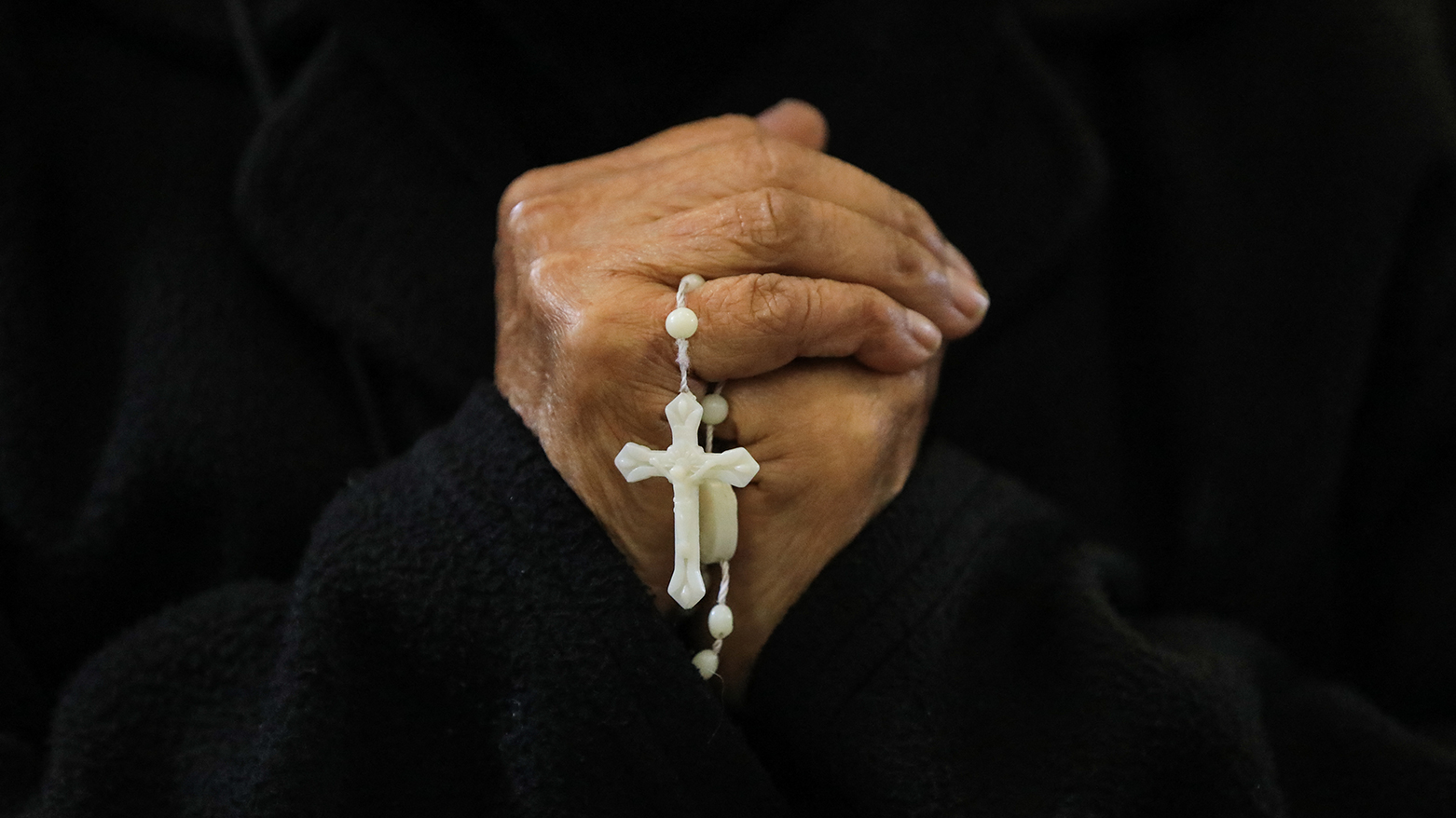 The hands of an elderly woman holding a crucifix are seen during a mass in honour of newly elected Pope Leo XIV, in Callao, Peru on May 9, 2025. (Photo: AFP)