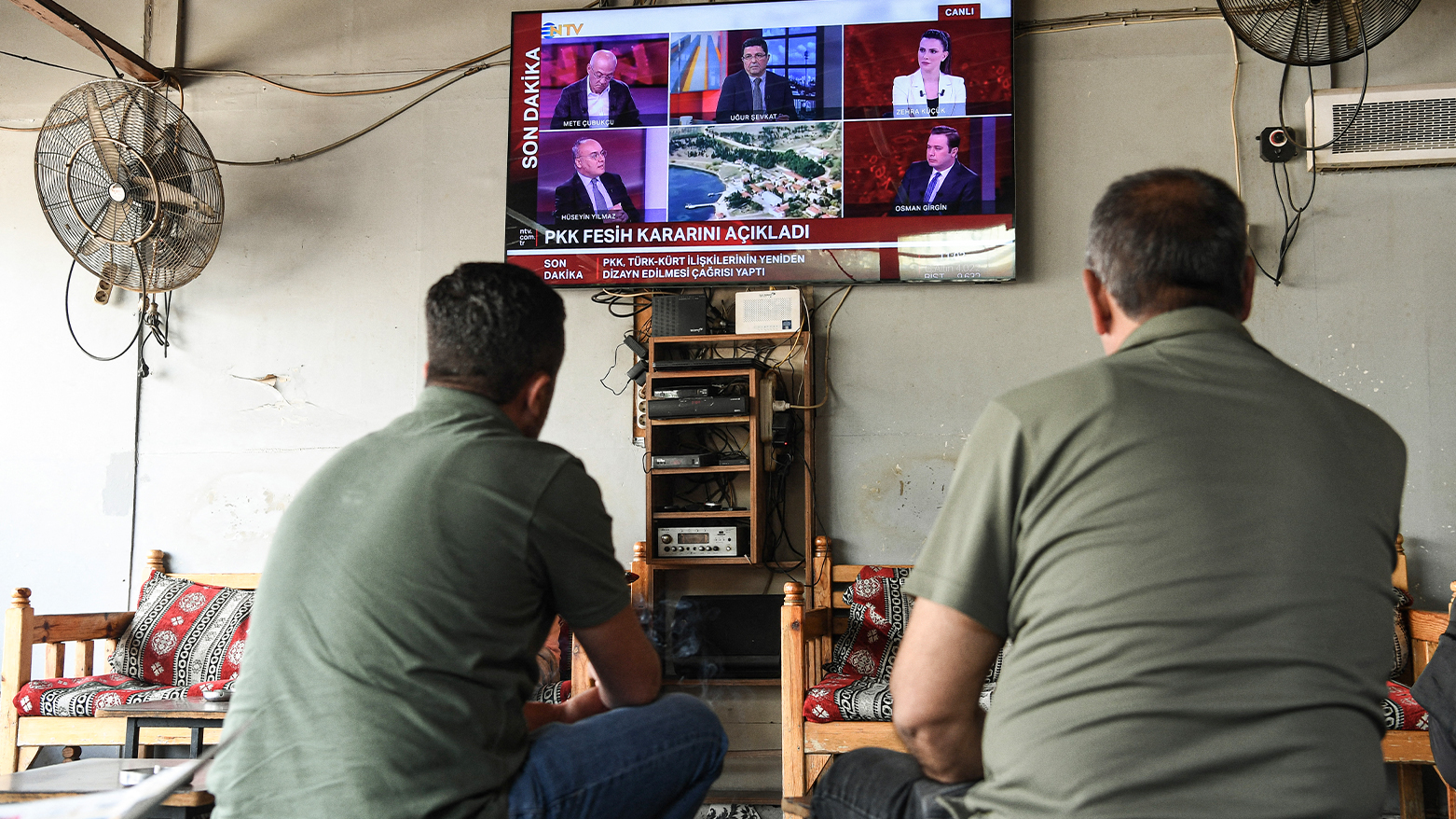 Men watch news of the PKK’s dissolution on TV in a tea house in Diyarbakir, May 12, 2025. (Photo: AFP)