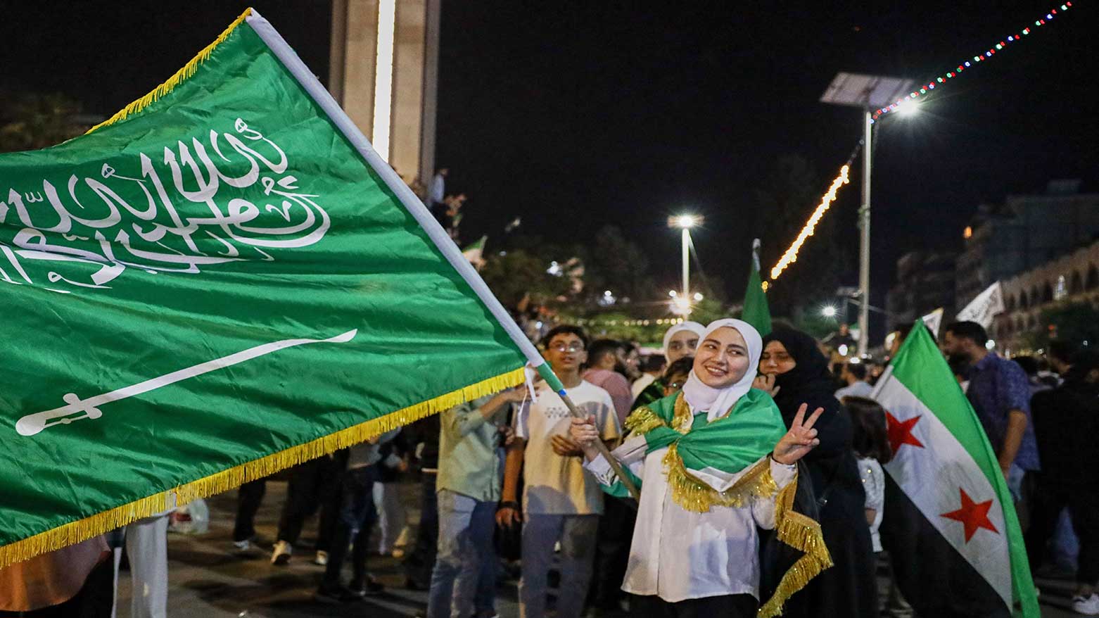 A girl holds a Saudi flag in Homs, Syria, as she celebrates Trump's plan to ease sanctions on Syria and normalize relations with its new government. May 13, 2025.  (Photo: AP)