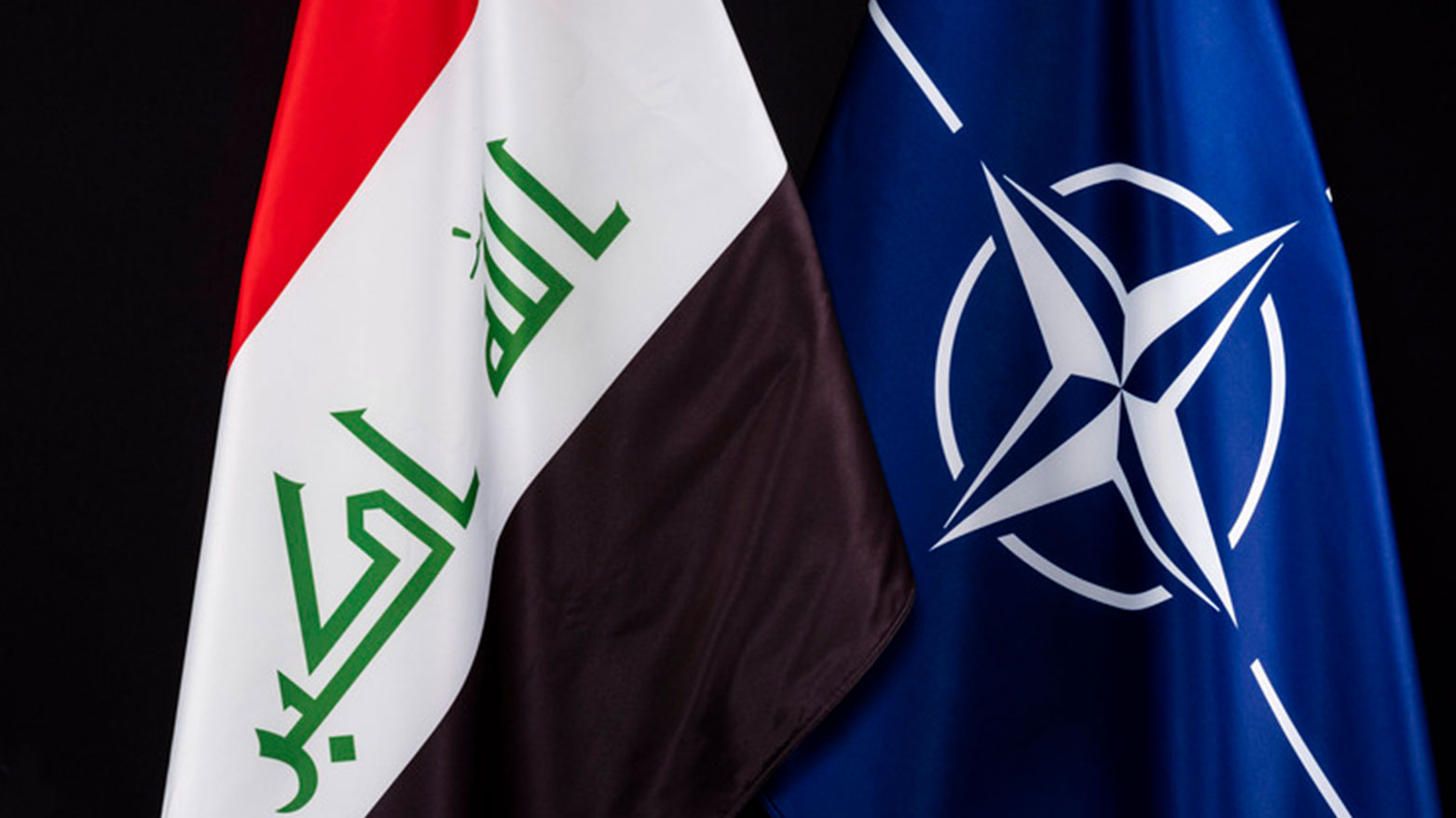 The flag of Iraq (left) and NATO. (Photo: NATO)