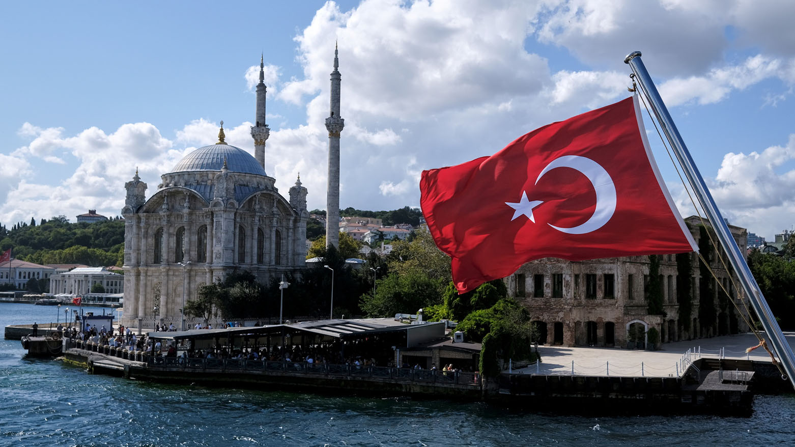 A Turkish flag is pictured on a boat with the Ortakoy Mosque in the background in Istanbul, Türkiye September 5, 2021. (Photo: Reuters)