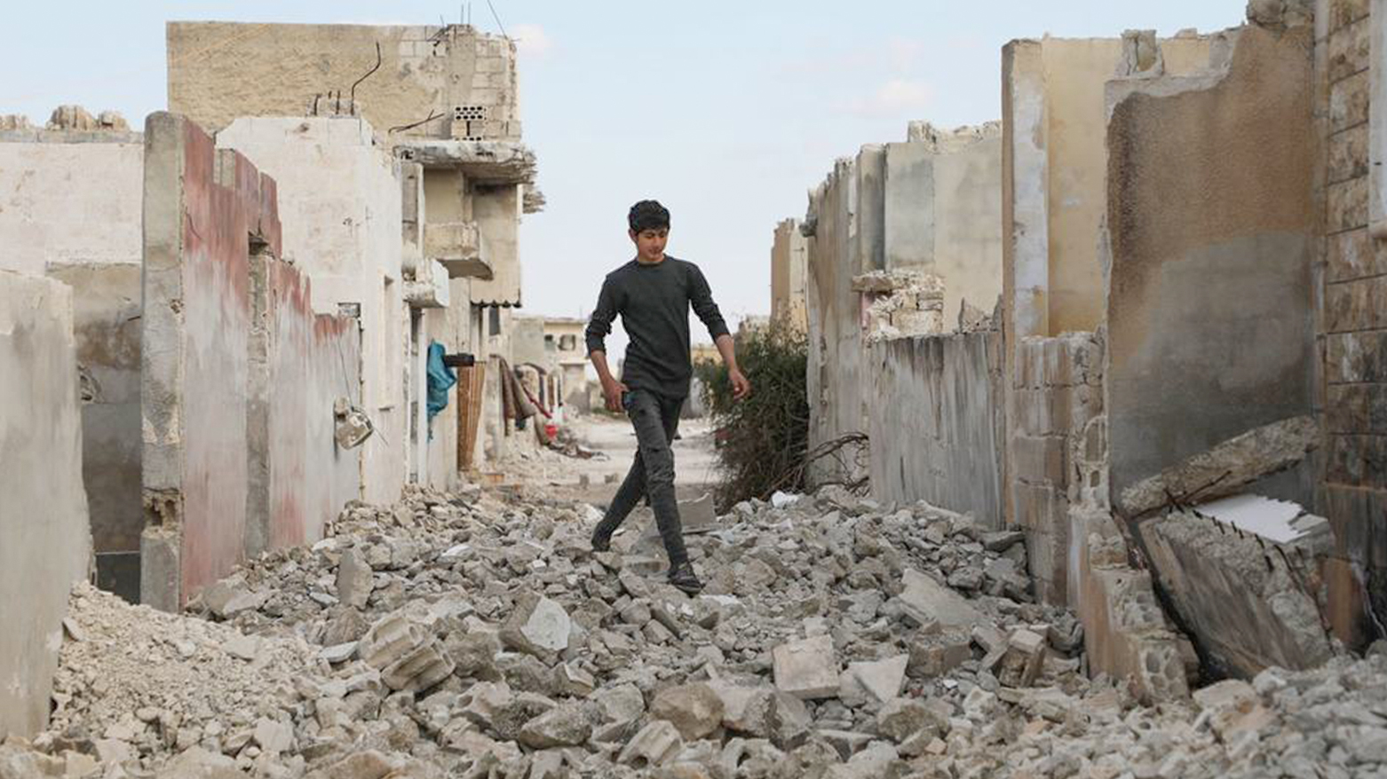 A boy walks among destroyed houses in Idlib Governorate, Syria. (Photo: UN)