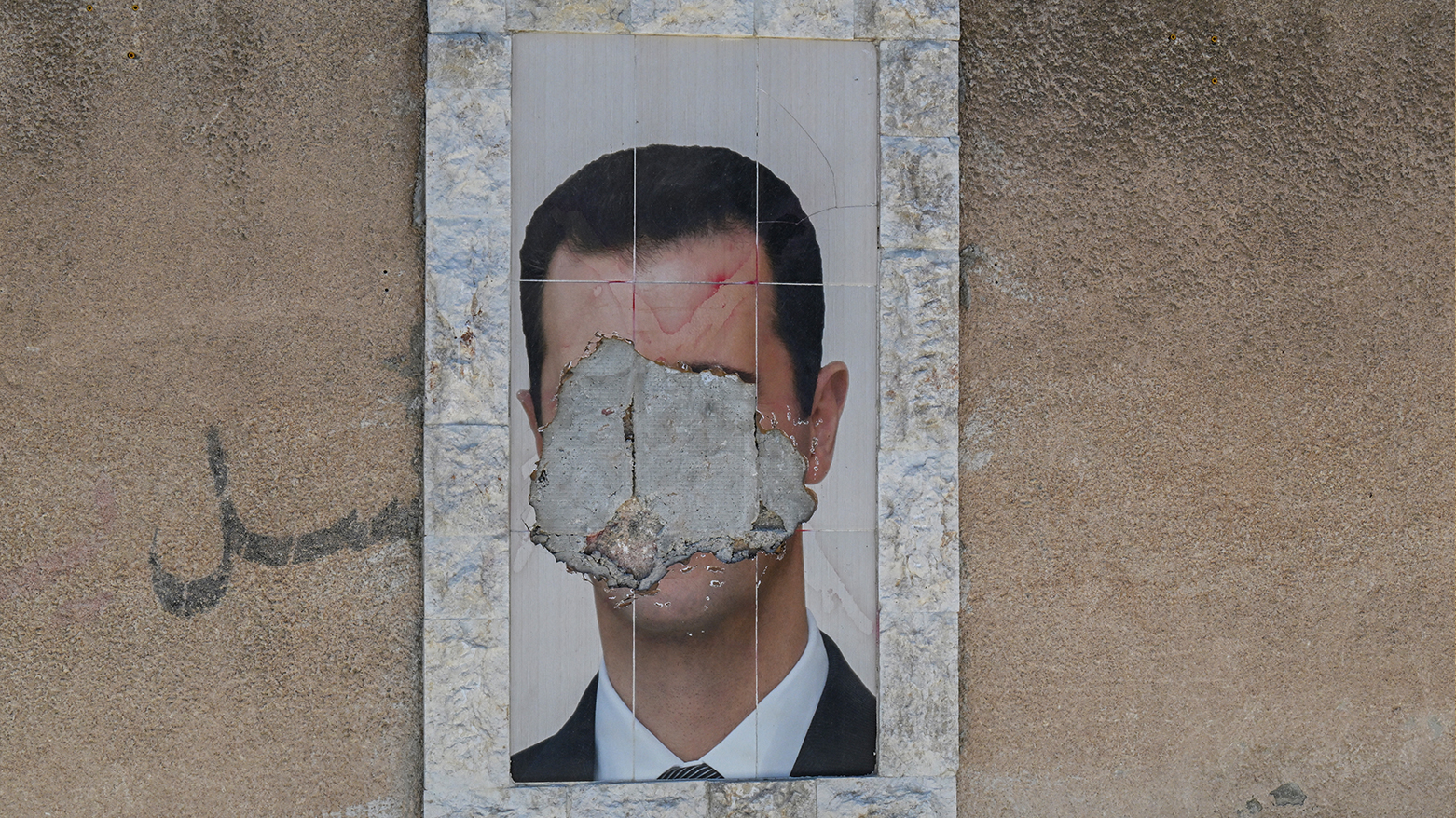 A defaced portrait of Syria's ousted president Bashar al-Assad hangs on a wall in the capital Damascus on Jun. 2, 2025. (Photo: AFP)