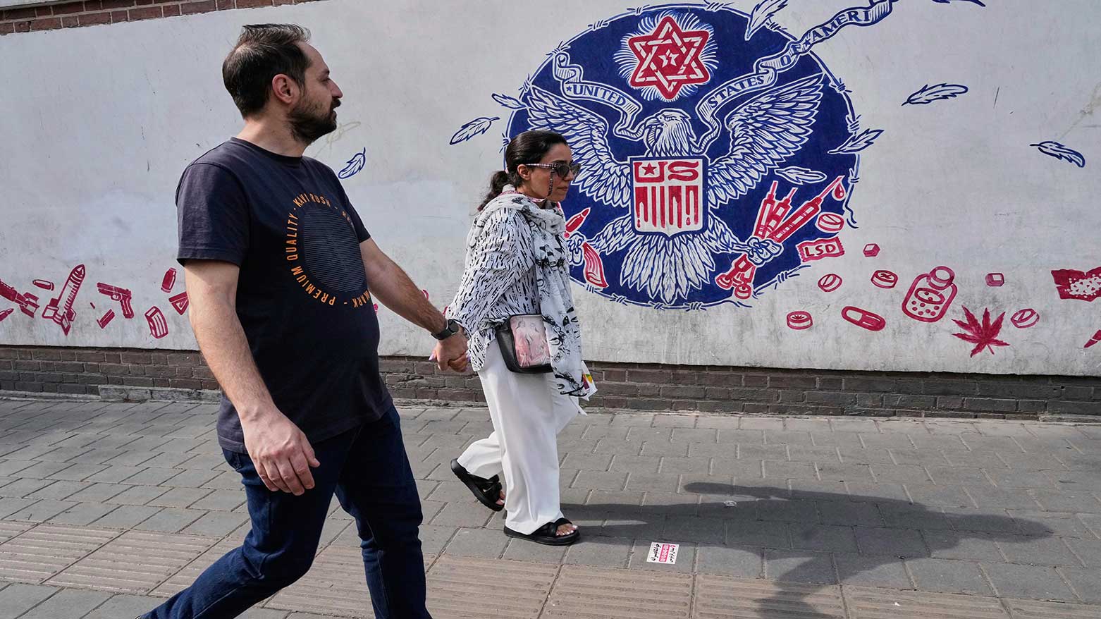 People walk past a state-sponsored anti-U.S. mural painted on the wall of the former U.S. Embassy in Tehran, Iran, May 7, 2025. (Photo: AP/Vahid Salemi)