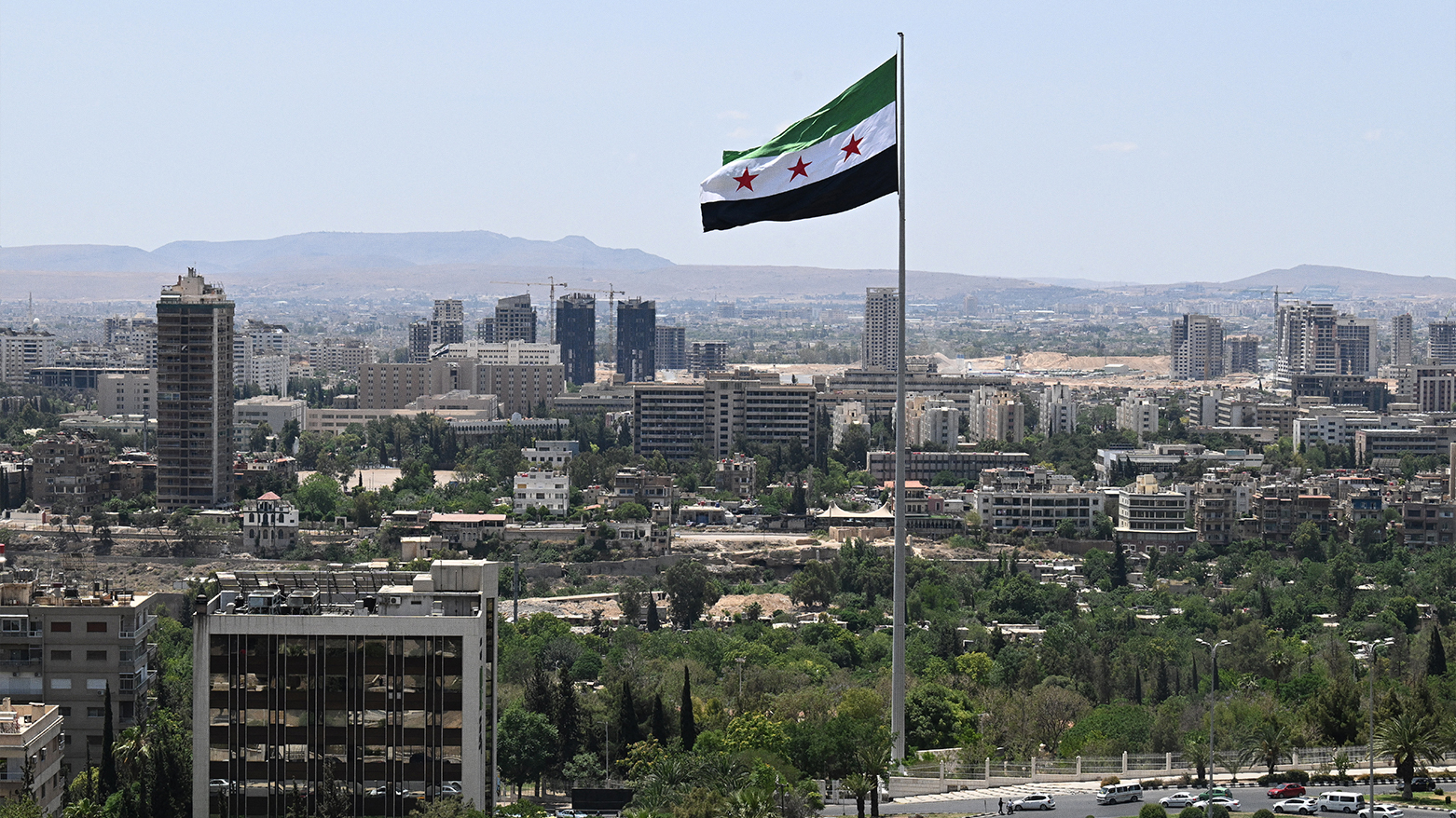 A large Syrian flag flutters above Tishreen Park in Damascus on June 4, 2025. (Photo: AFP)