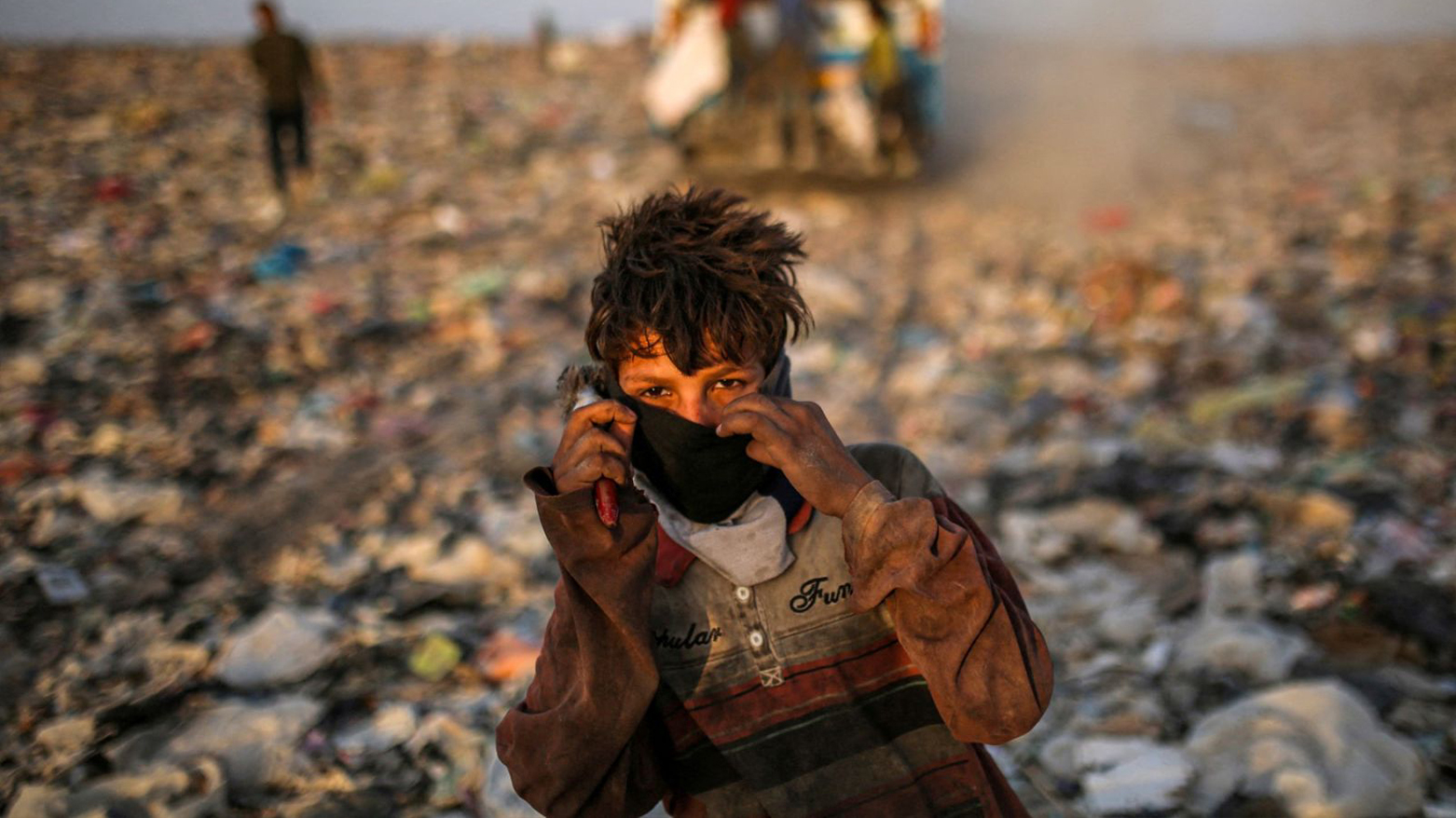 A youth poses for a picture in a landfill while searching for recyclable material for sale in Basra on Jun. 22, 2023. (Photo: AFP)