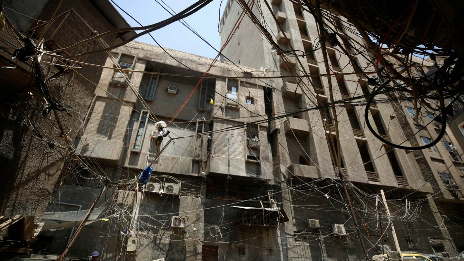 Electrical wires hang between buildings in a street in Iraq's capital Baghdad on July 13, 2023. (Photo: AFP)