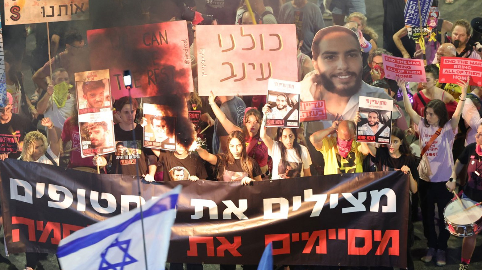 متظاهرون يحملون لافتات خلال احتجاج مناهض للحكومة الإسرائيلية (فرانس برس)