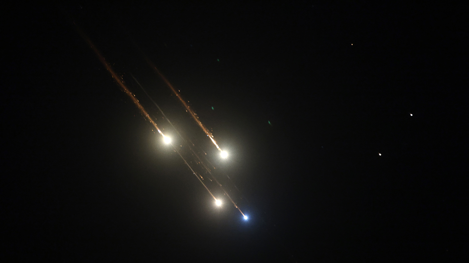 Debris of missiles fired from Iran toward Israel leave trails in the night sky over Nablus. (Photo: AFP)