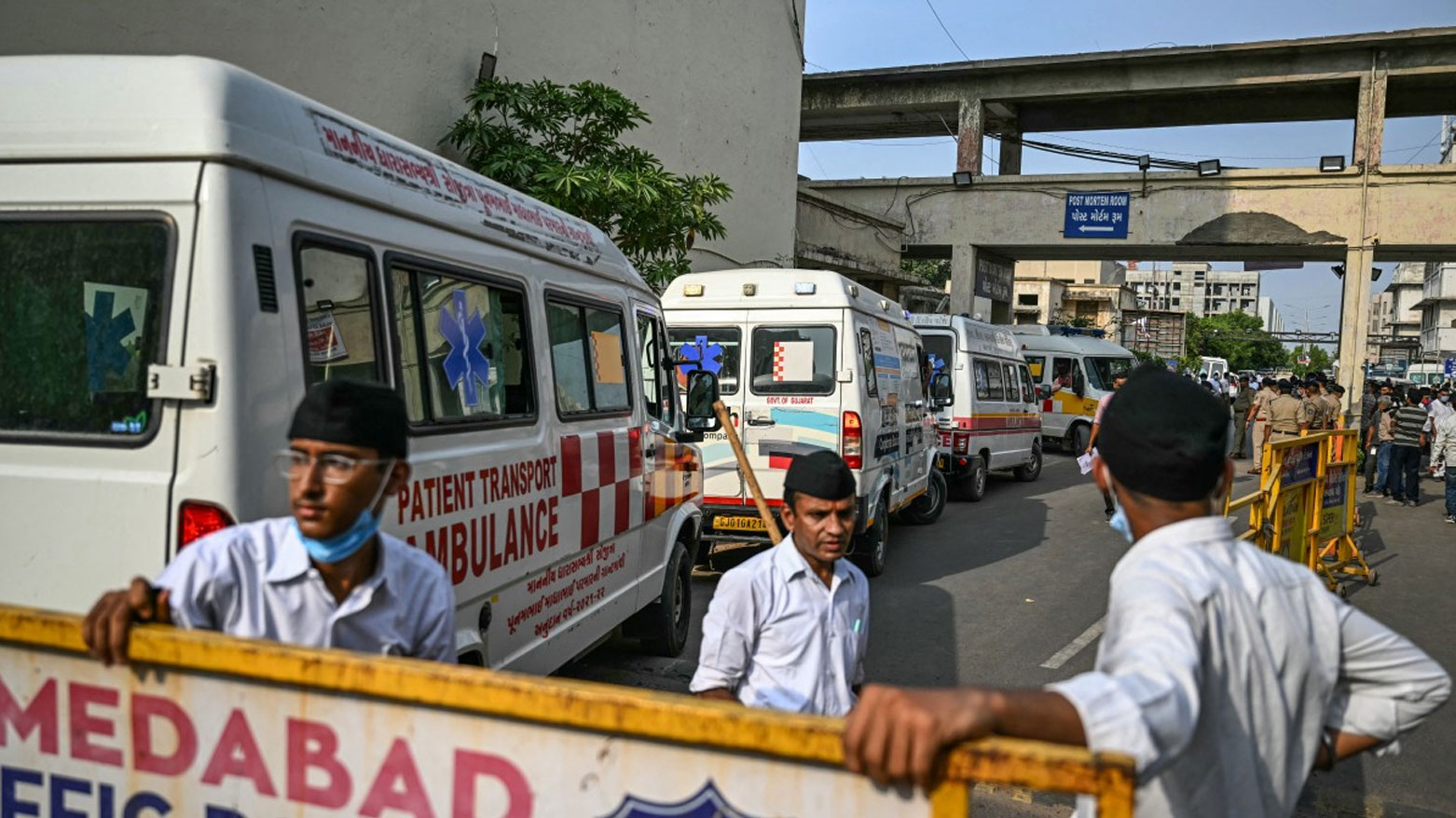 سيارات إسعاف متوقفة قرب غرفة التشريح في أحد المستشفيات لنقل جثث الضحايا إلى مشرحة في أحمد آباد (فرانس برس)