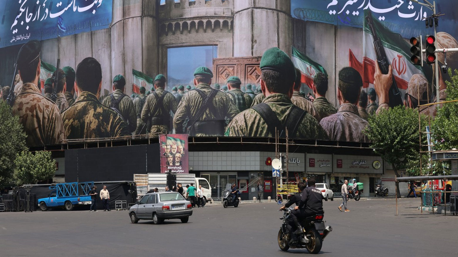 إيرانيون يمرون أمام ملصق مناهض لإسرائيل في ساحة الانقلاب بطهران (فرانس برس)