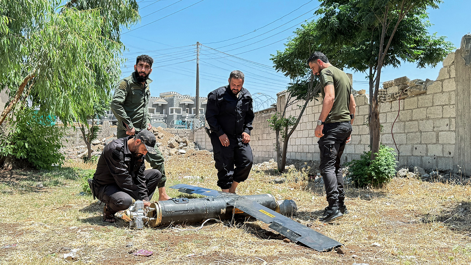 Security officers affiliated with Syria's interior ministry inspect the remains of a reported Iranian drone that fell in the northern fields of Jasim city near Daraa in southwestern Syria on June 14, 2025. (Photo: AFP)