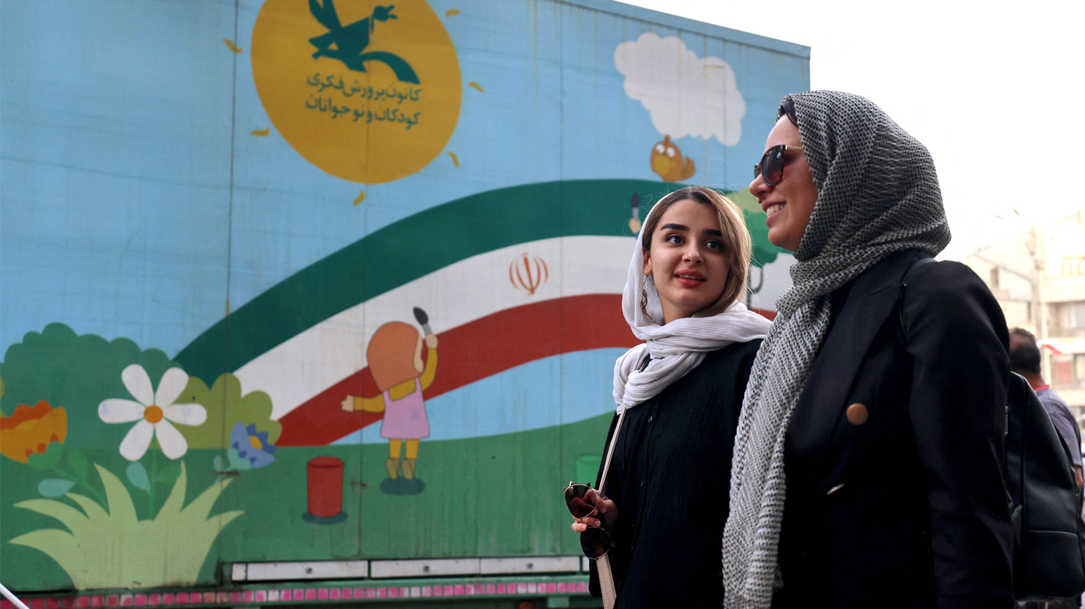 نساء إيرانيات يسيرن في ساحة الانقلاب بطهران بعد وقف إطلاق النار (فرانس برس)