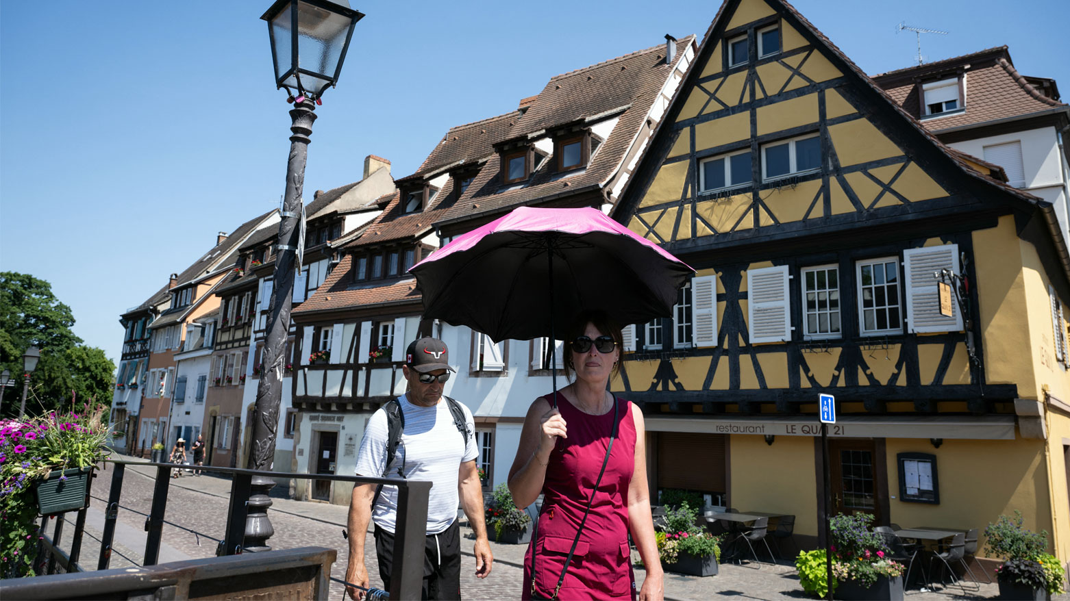 امرأة تحمل مظلةً لحماية نفسها من الشمس في كولمار، شرق فرنسا (فرانس برس)