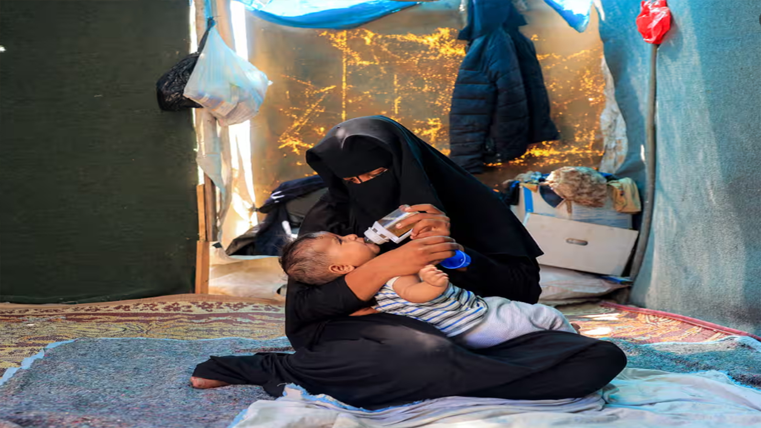 ئافرەتێکی فەلەستینی و منداڵە ساواکەی