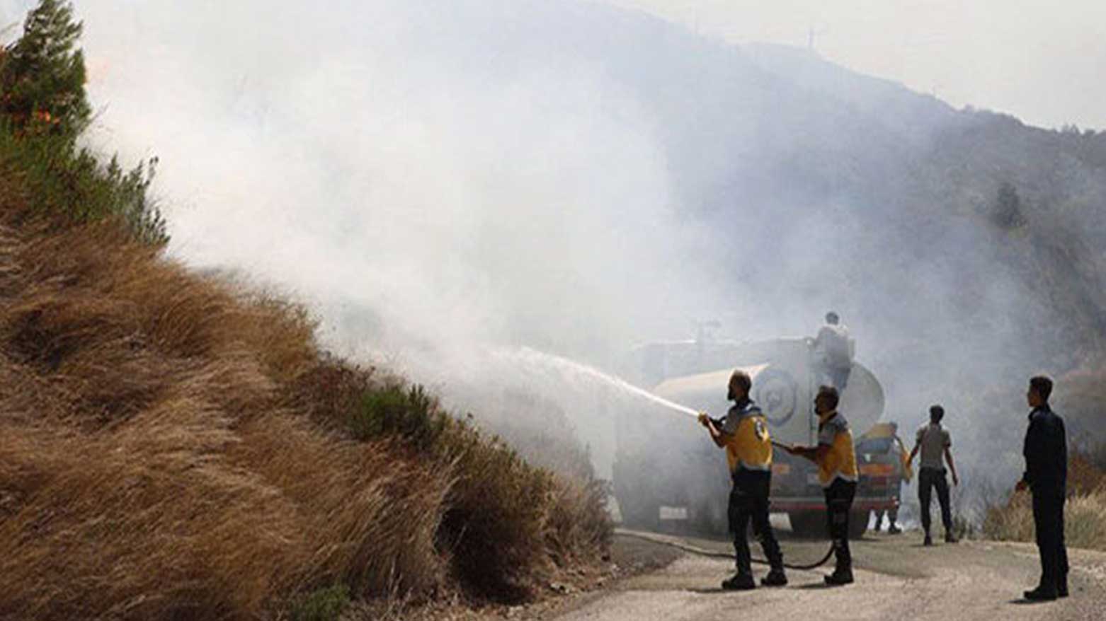 Syrian Civil Defense teams continue their intensive efforts to extinguish the massive wildfires raging in the Latakia countryside for the third consecutive day, July 5, 2027. (Photo: SANA)