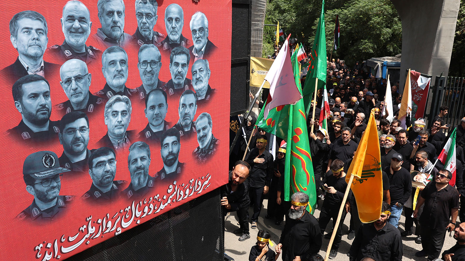 Iranian Shiite Muslims walk next to a poster bearing the portraits of scientists and military commanders killed during the 12-day war between Iran and Israel, July 5, 2025. (Photo: AFP)