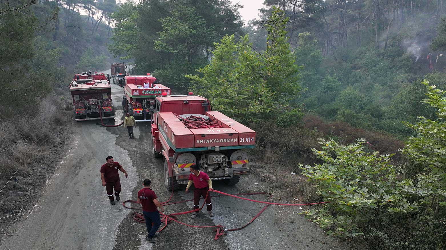 An aerial view shows Turkish firefighters preparing their hose during the forest fire in the coastal Syrian province of Latakia, July 5, 2025. (Photo: AFP)