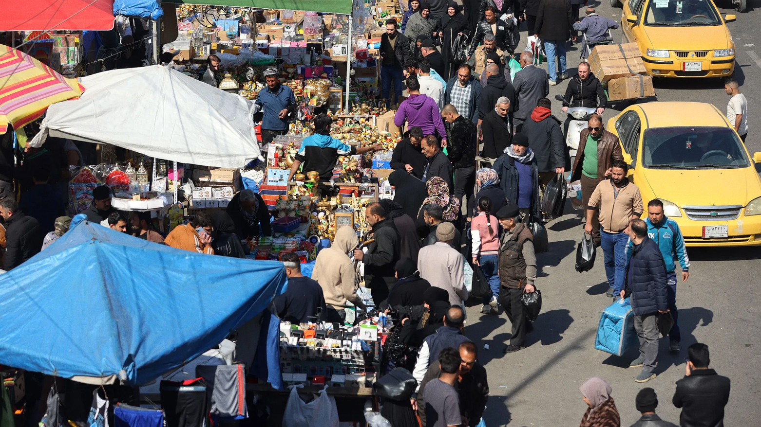 People walk outside Shorja market in central Baghdad on February 27, 2025. (Photo: AFP)