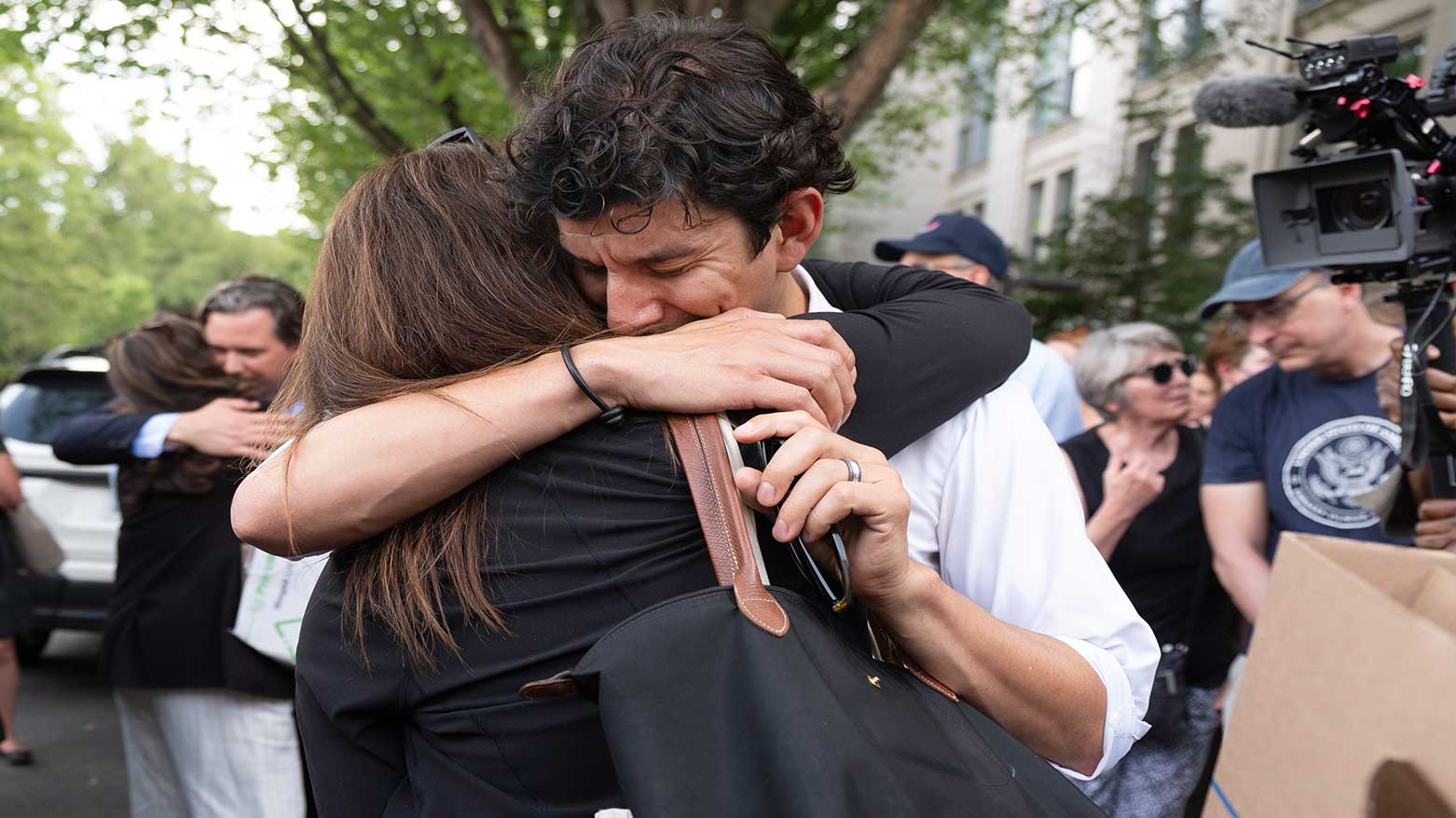 A fired State Department employee, left, is greeted outside of the Harry S. Truman Building, the headquarters of the State Department, in Washington, Friday, July 11, 2025. (Photo: AP)