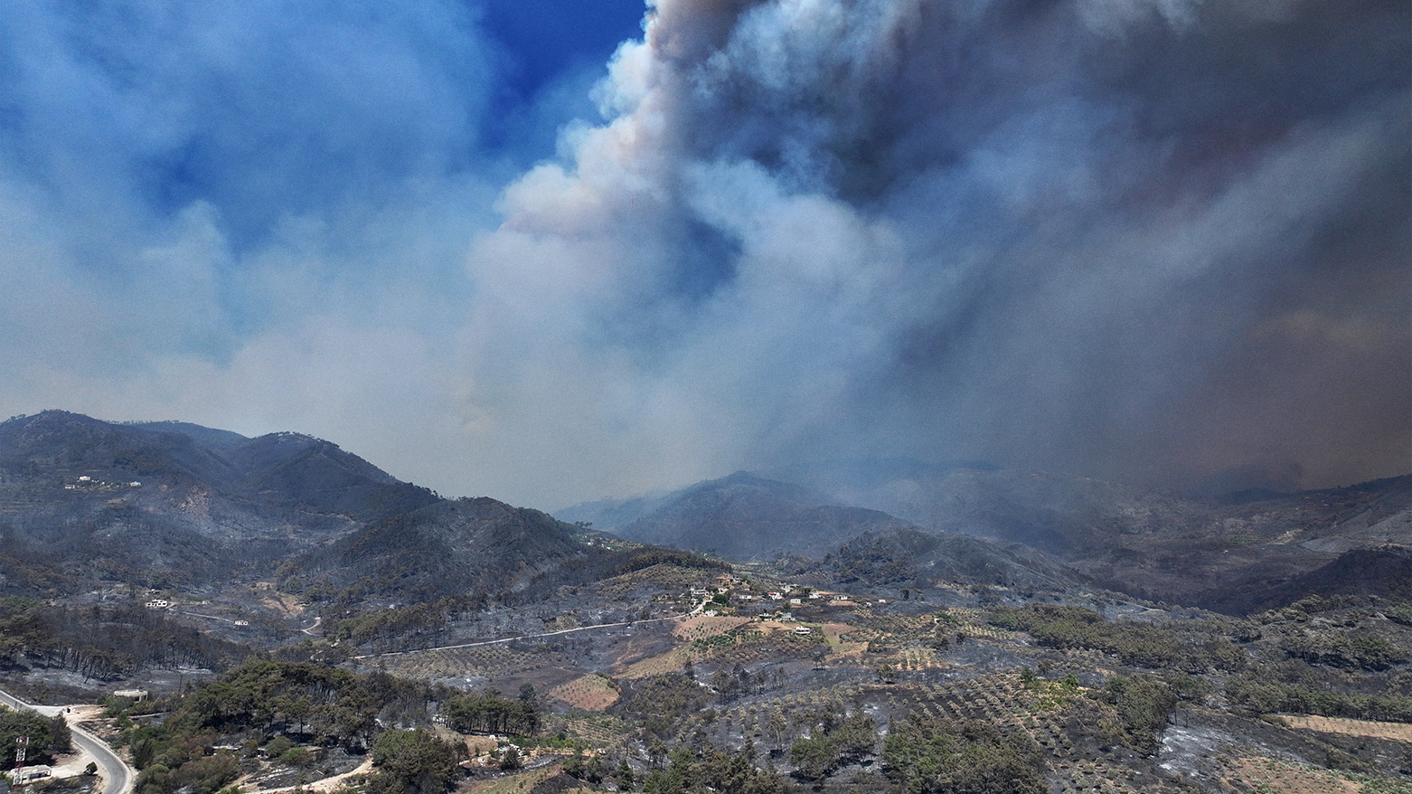 An aerial view shows smoke billowing from a forest fire in the coastal Syrian province of Latakia on July 5, 2025. (AFP)