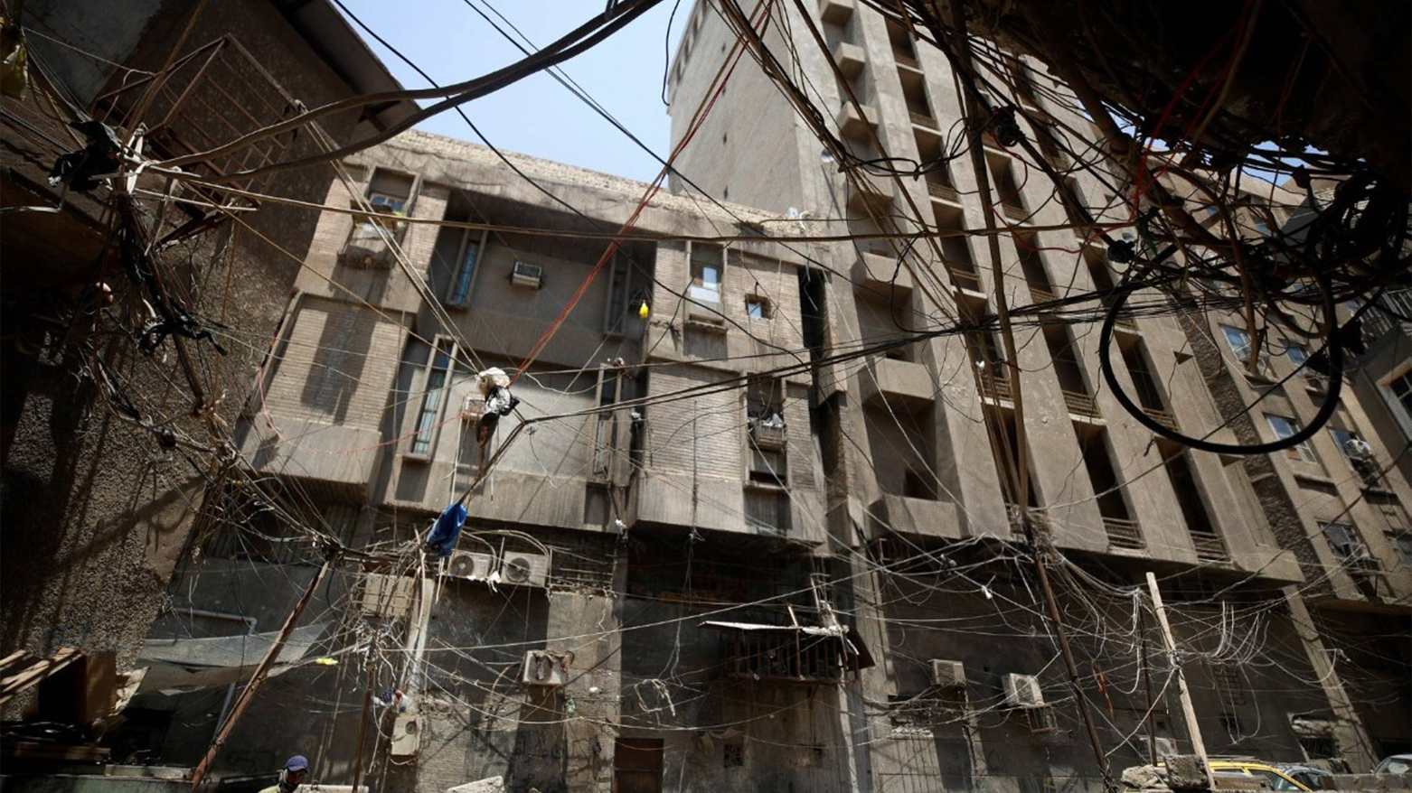 Electrical wires hang between buildings in a street in Iraq's capital Baghdad on July 13, 2023. (Photo: AFP)